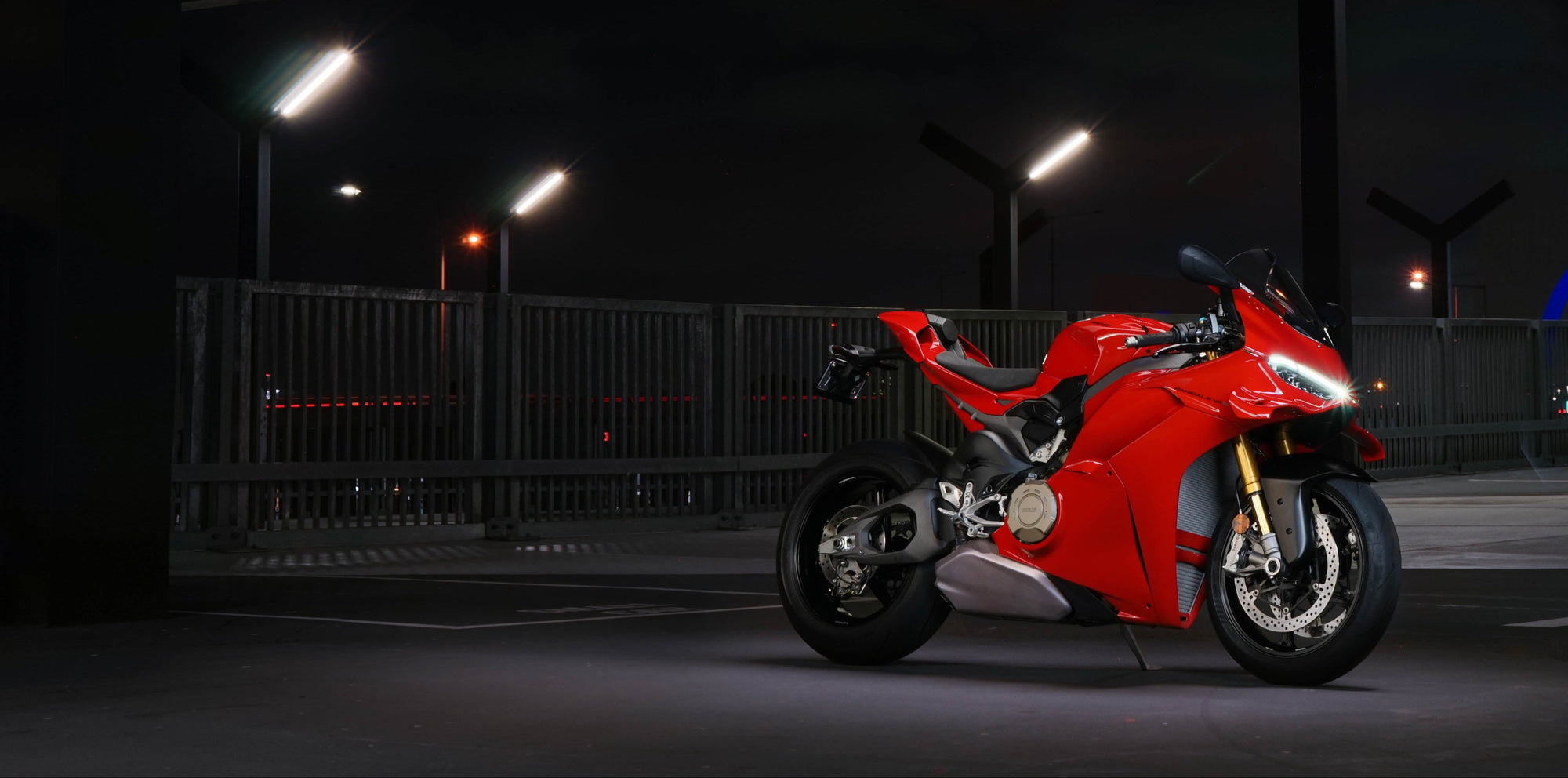 Red motorcycle parked in a dark parking lot with visible branding.